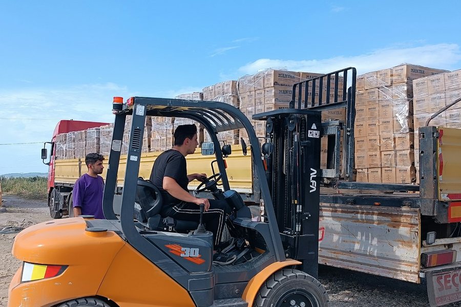 トラックの荷台に積まれた荷を運ぶフォークリフト